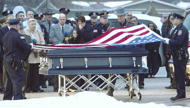 The family of Lt. Charles Shafer along with area officers surround the casket during the funeral ceremony.  (Patrica Schaeffer / The (Lisbon) Morning Journal)